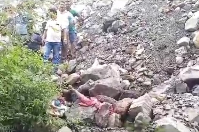 पत्थरों के नीचे दबा मिया शव 